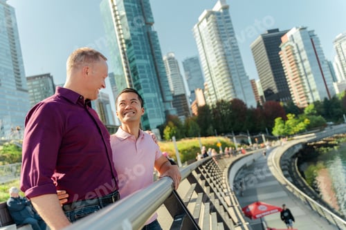 Preview: Portrait of mature homosexual men looking at each other hugging standing on urban street
