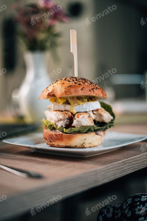 Preview: Delicious fresh chicken burger on a plate on the table in a diner