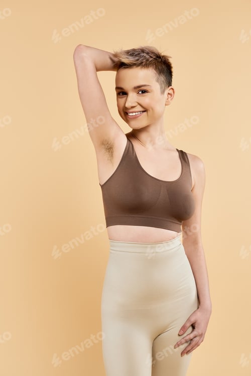 Preview: Smiling Woman in Sportswear Poses on Plain Background