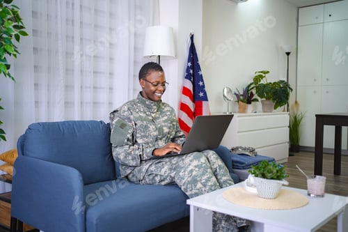 Preview: Smiling African American Female Soldier Using Laptop at Home