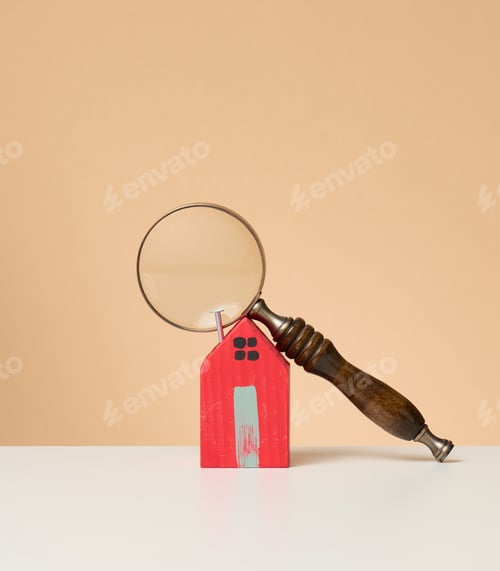 Preview: Magnifier and wooden house on a brown background. Real estate rental