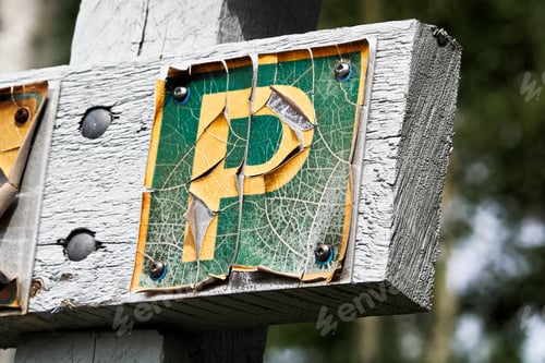 Preview: A faded peeling parking sign on wood