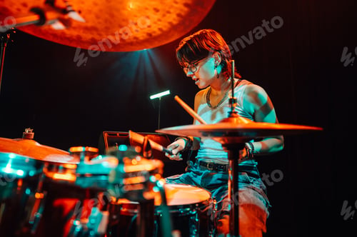 Preview: Drummer performing live on stage with colorful lighting