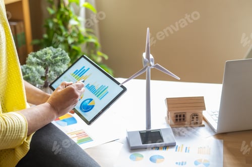 Preview: Engineer or technician studying sustainable energy solutions,examining solar, wind energy in office
