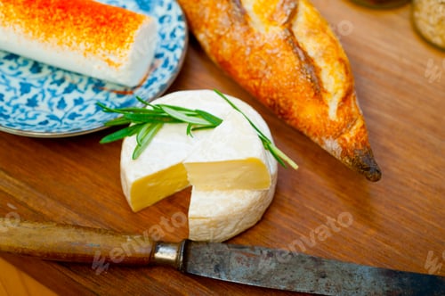 Preview: French cheese and fresh baguette on a wood cutter
