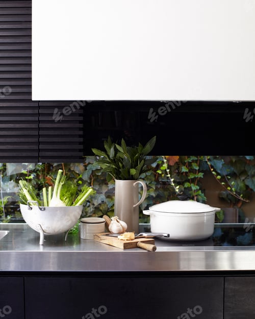 Preview: Modern kitchen counter with cooking utensils and plants.