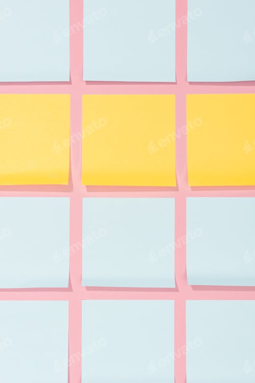 Preview: view from above of blank yellow and blue stick it notes on pink