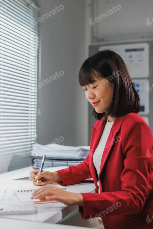 Preview: Woman writing notes during business work at office