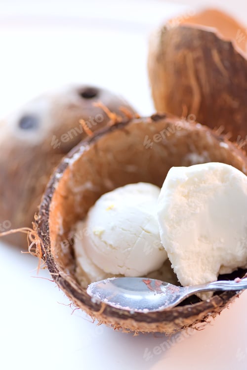 Preview: Vanilla sweet natural ice-cream in coconut bowl with spoon on a white background