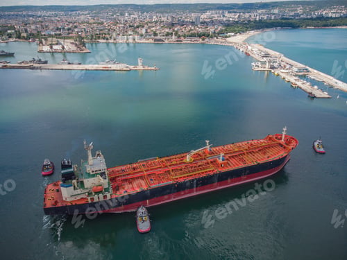 Preview: Aerial view of tanker ship with escorting tug leaving port