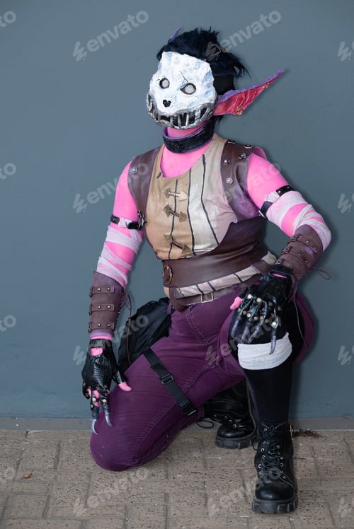 Preview: Female cosplayer dressed as a pink monster with a skull mask