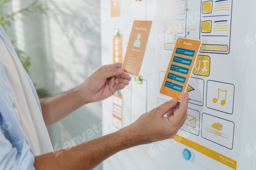 Preview: A designer is developing UX UI layouts, reviewing mobile app prototypes