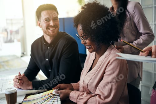 Preview: Smiling designers discussing color swatches together at an office desk