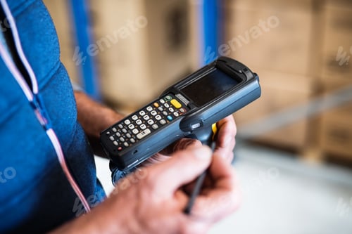 Preview: Male warehouse worker with barcode scanner.