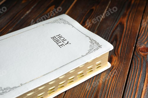 Preview: Old hardcover Bible on wooden table, closeup. Religious book