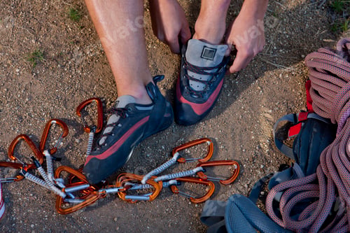 Preview: Cropped shot of young male climber putting on trainers