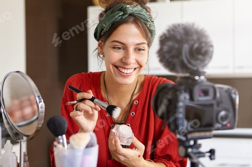 Preview: Horizontal shot of popular female beauty blogger presenting video tutorial, doing bridal make up usi