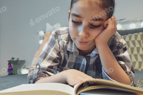 Preview: Child Reading Book on Bed in Bedroom