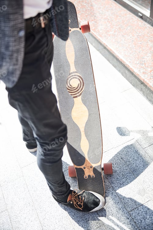 Preview: Stylish man stepping on a cool longboard