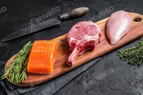 Preview: Raw meat steaks - fish salmon, beef veal and turkey. Black background. Top view