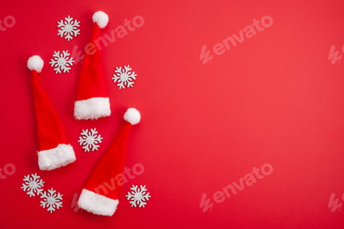 Preview: Festive christmas decoration with red Santa hats over red background