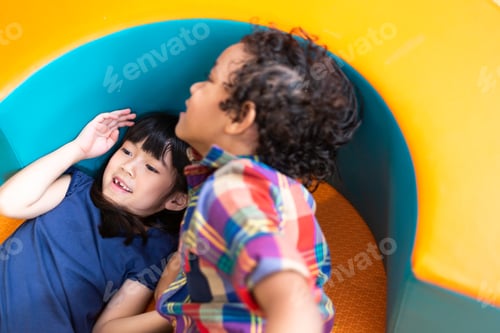 Preview: Asian little girl playing with boy in playroom