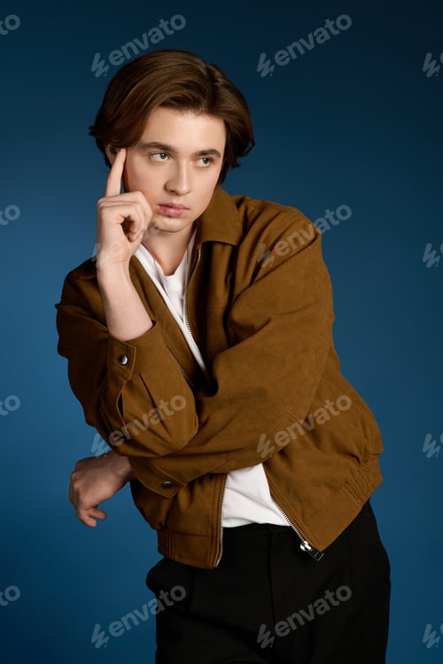Preview: Young handsome man poses stylishly against a vibrant backdrop showcasing modern fashion