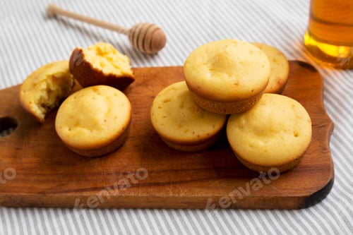 Preview: Homemade Cornbread Muffins on a rustic wooden board, side view. Close-up.