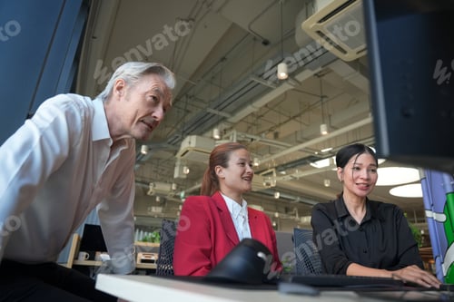 Preview: Diverse team collaborating at computers in a modern office environment