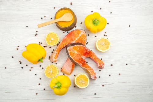 Preview: top view fresh meat slices with lemon slices and bell-peppers on a white background animal fish rib