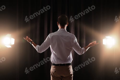 Preview: Motivational speaker with headset performing on stage, back view