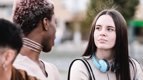 Preview: Cool transgender man and a friend talking together siting outdoors