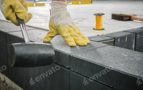 Preview: Worker Levelling Patio Concrete Floor Bricks Close Up