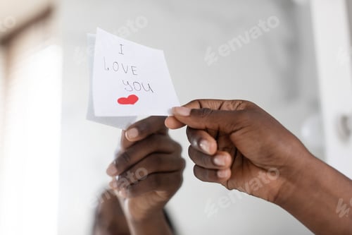 Preview: Black Female Hand Putting Sticky Note With Love Message On Mirror, Closeup