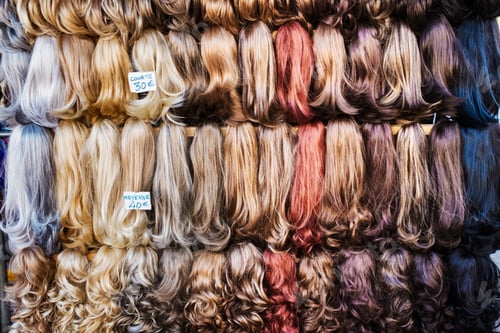 Preview: A display of hair extensions and hair pieces of different colours.