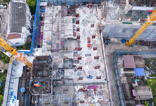 Preview: Aerial view of busy industrial construction site workers working. Development high rise building.