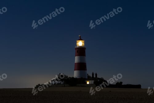 Preview: Lighthouse under dark blue sky at night
