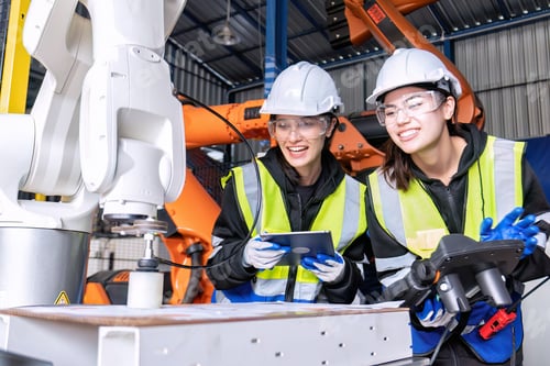 Preview: Women engineer team together at work in modern advanced robot welding machine sell service factory