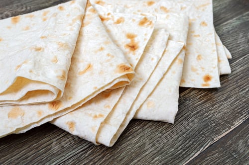 Preview: Thin pita bread on wooden background.