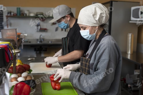 Preview: Hispanic chefs cooking in the kitchen wearing protective medical face masks