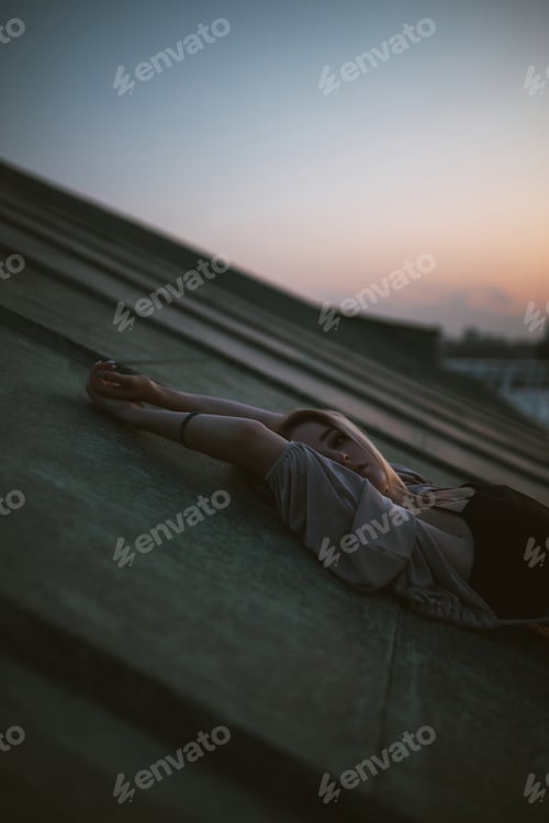 Preview: Photo shoot on roof. Young woman posing in roof at sunset. People, lifestyle, relaxation concept.