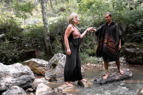 Preview: A young woman is taking the hand of her boyfriend barefoot in the river