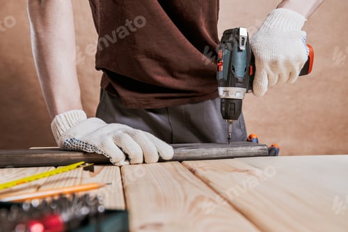 Preview: Worker Using Cordless Drill on Wooden Beam