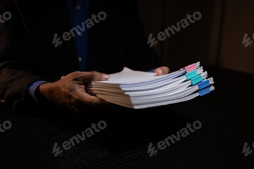 Preview: a businessman works overtime is his accounting firm's office until late at night