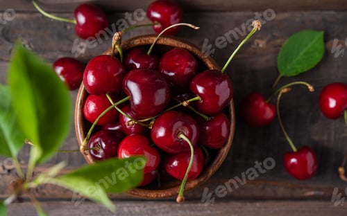 Preview: Fresh and sweet red cherries and cherry blossom in a wooden bowl on an old wooden table.