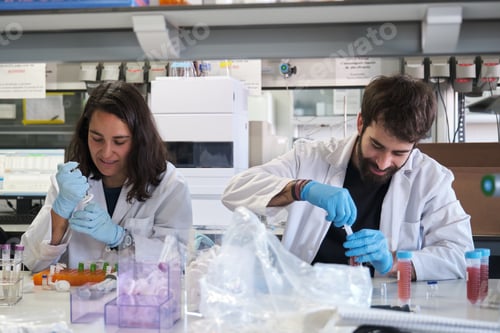 Preview: Two young phD students working in a real laboratory.