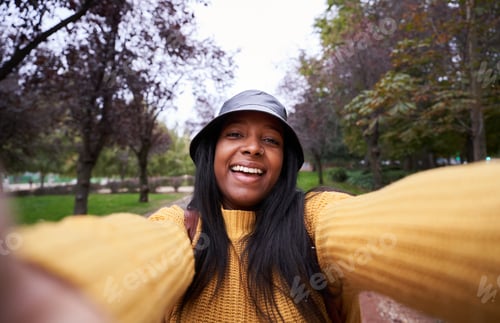 Visualização: Mulher afro-americana tirando uma selfie durante a viagem, ao ar livre em um parque.