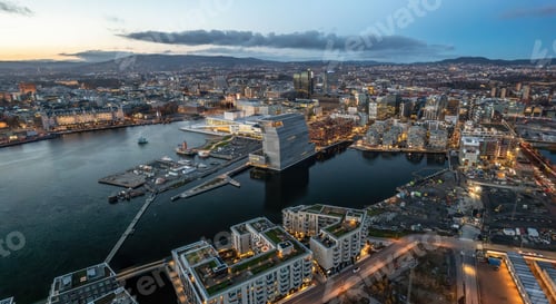 Preview: Aerial shot of Oslo at sunset, with lots of buildings and lights, surrounded by sea, Norway