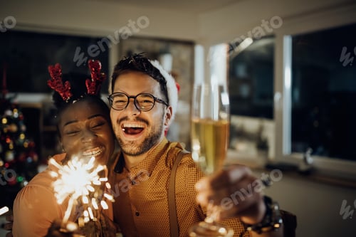 Preview: Cheerful couple celebrating New Year and having fun at home.