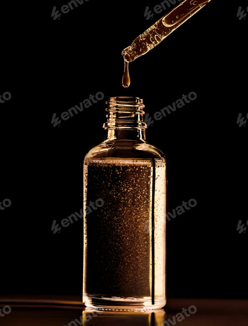 Preview: close-up of a serum oil pipette with a falling drop on a dark background